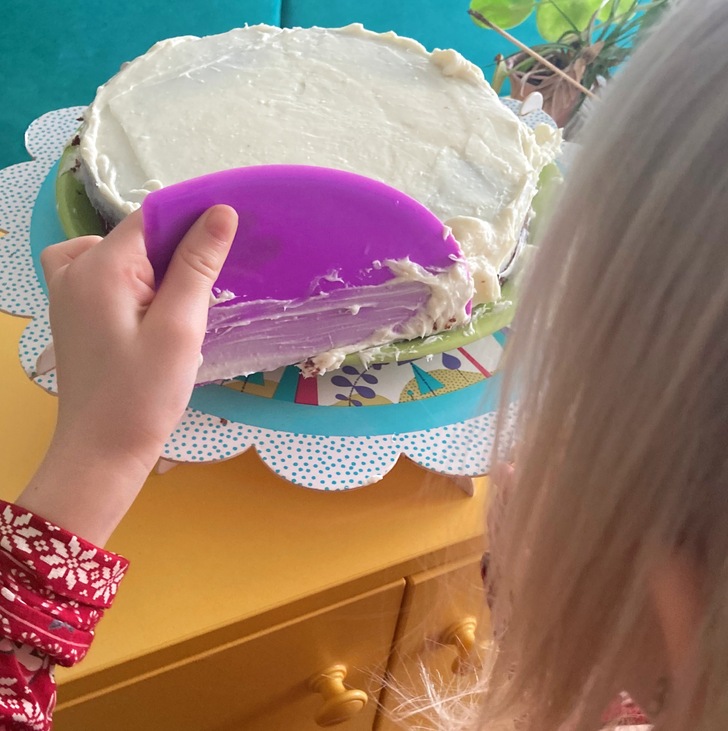kisgyerek keni a krémet a tortára (hátulról látszik)