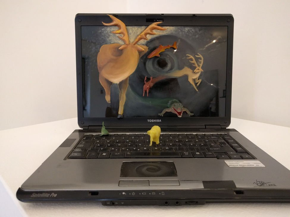 Laptop rajta festett állatok és műanyag állatfigurák